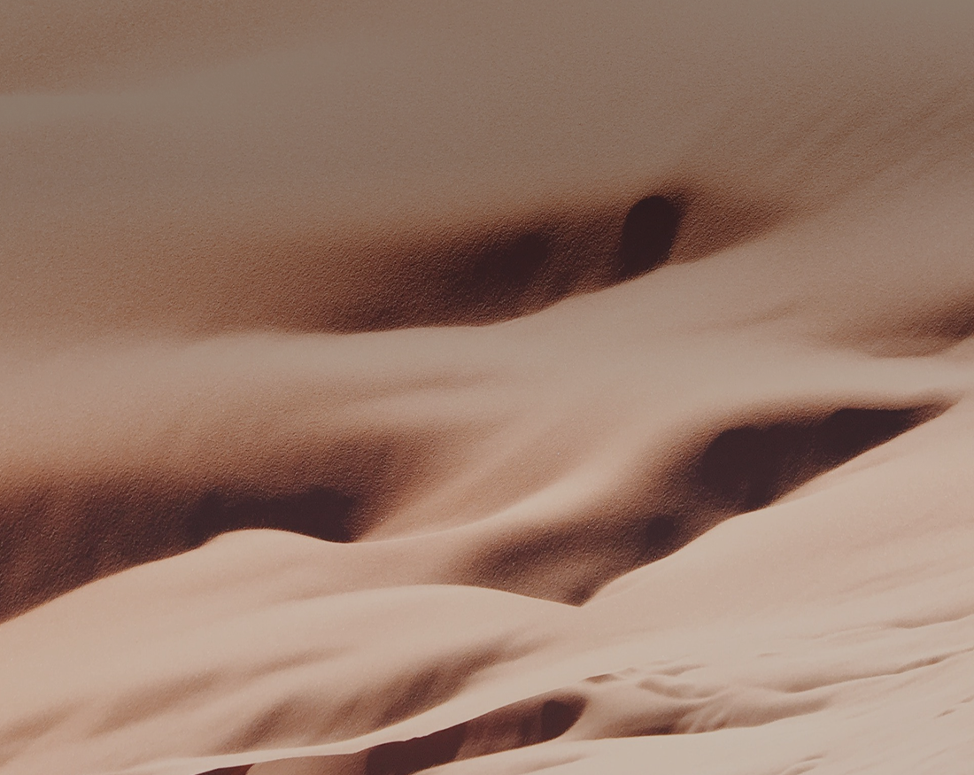Abstract pattern of soft, flowing sand dunes.