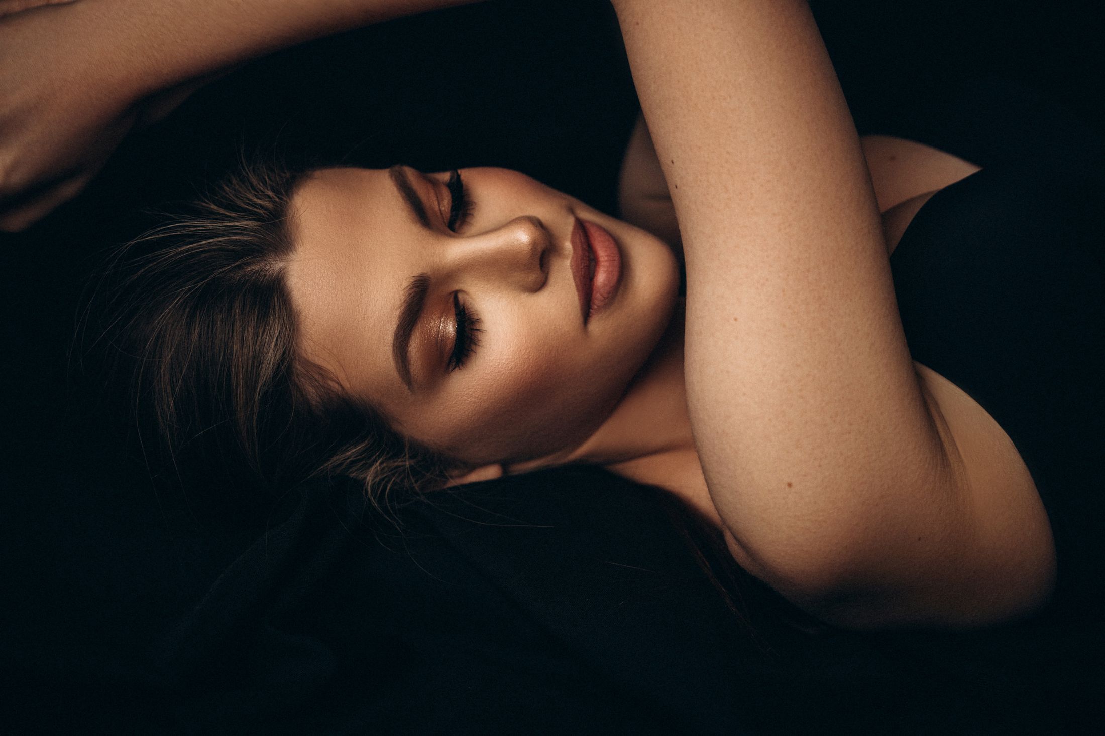 Woman with closed eyes, natural makeup, relaxed pose.