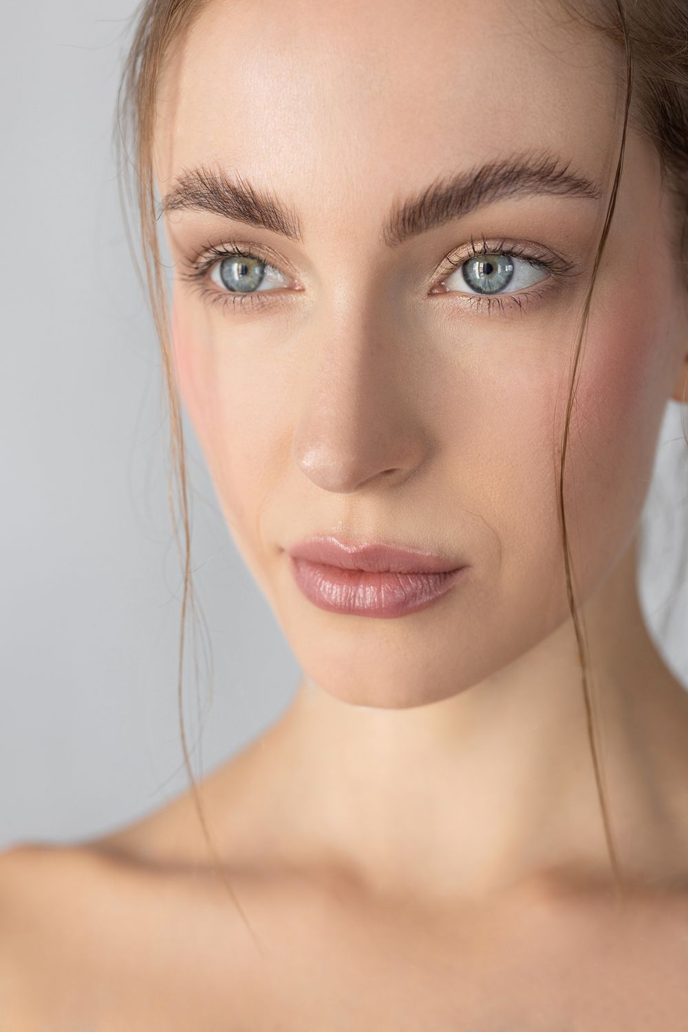 Close-up of a woman with striking blue eyes.